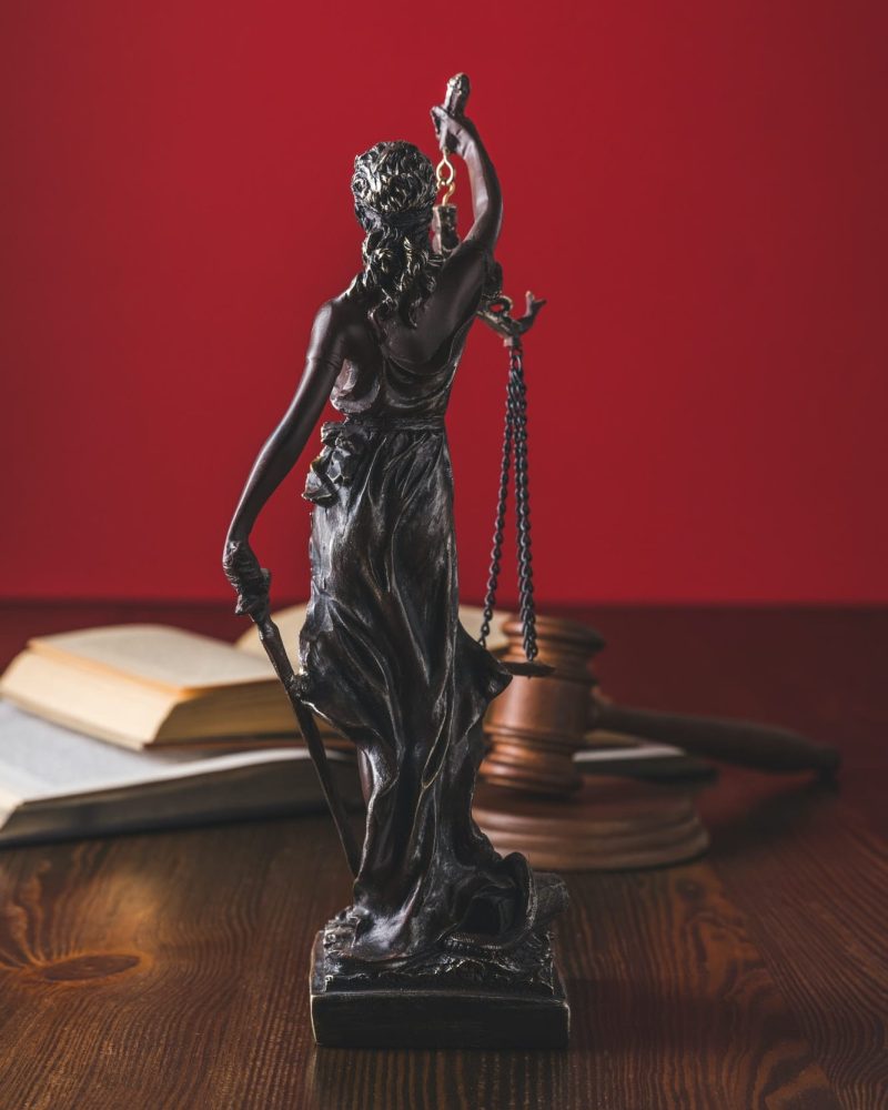 opened-juridical-books-with-lady-justice-statue-on-wooden-table-law-concept